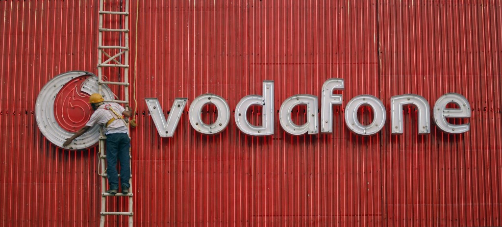 File photo of a worker replacing fluorescent lights on a Vodafone billboard in New Delhi